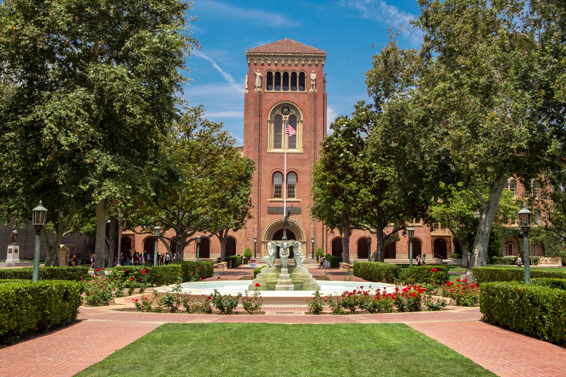 University campus with a brick tower and rose garden fountain